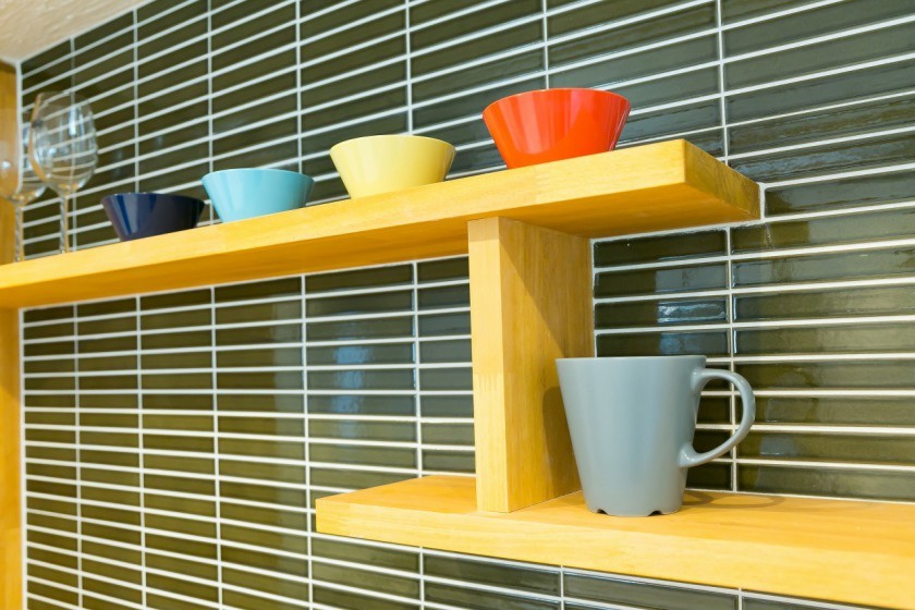 キッチンの壁には個性的なタイルを施した。お気に入りの食器を飾る棚も設置