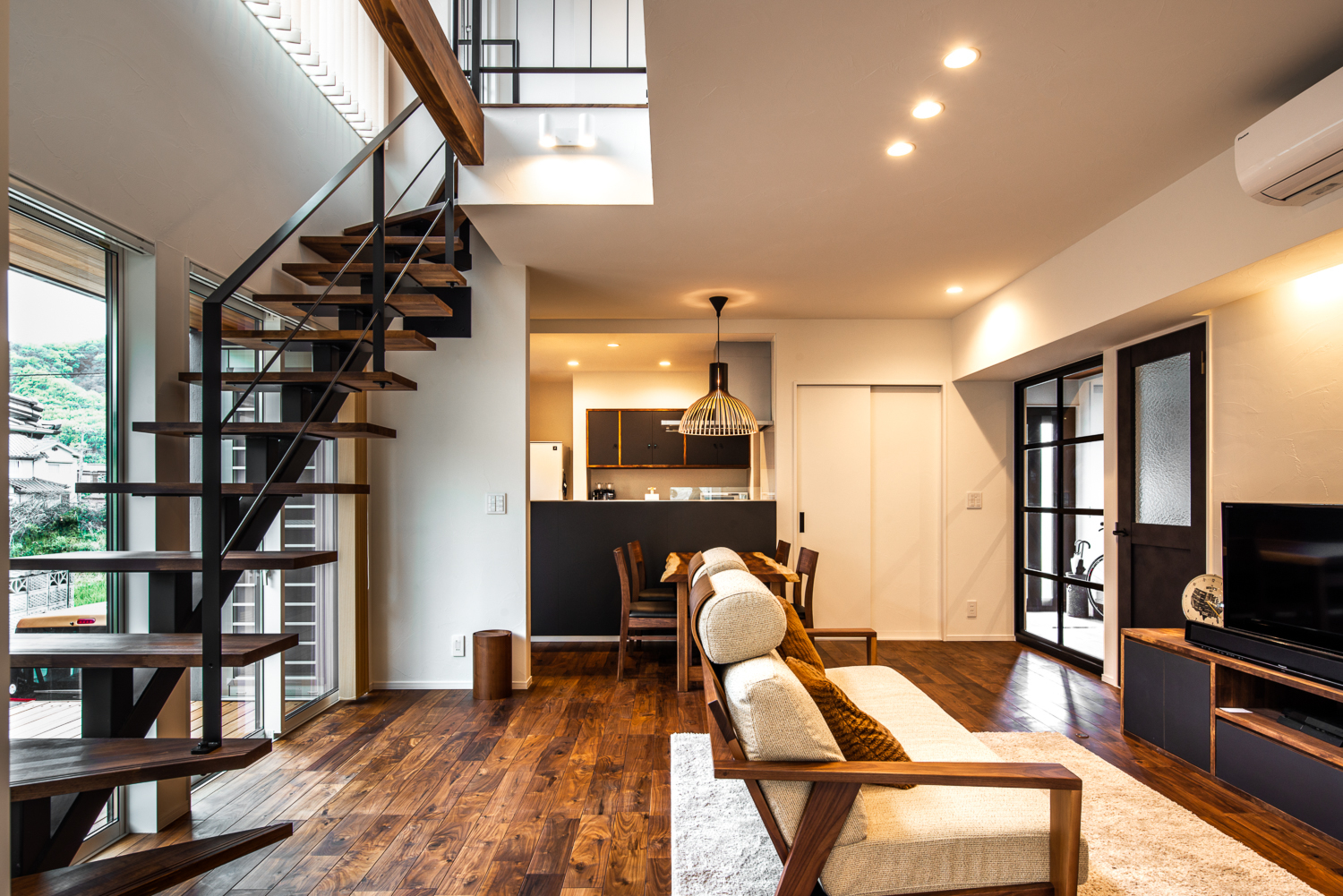 ブラックウォルナットの床は家具・建具・階段の色とも合い、室内を落ち着いた雰囲気にしてくれる。